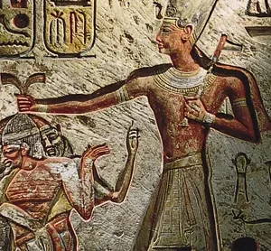 Ancient Egyptian wall carving from *The History of Saul, David, and Solomon: Israel's First Three Kings*, depicting a pharaoh holding a crook and flail while grasping the hair of two prisoners. Hieroglyphs are present in the background.
